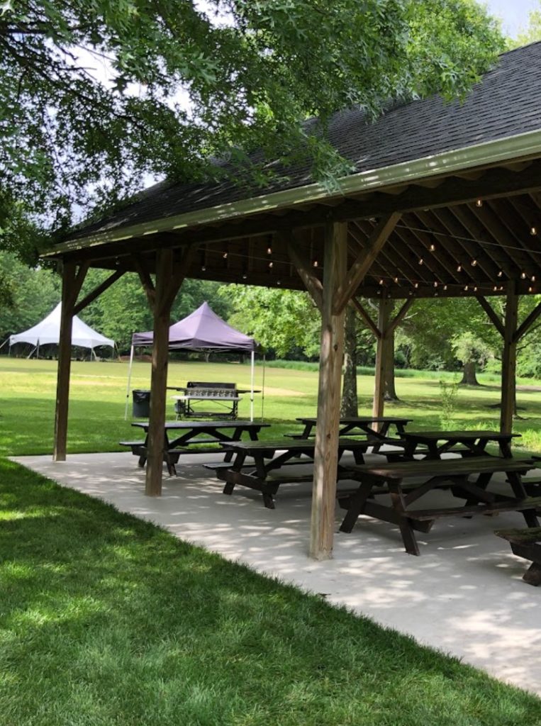 An outdoor pavilion with picnic tables for end-of-summer party 